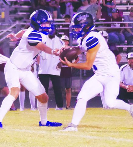 SNOOK’S BRETT Withem hands off to Tristan Yen in the Iola game last Friday. Photo courtesy of Steve Ingram