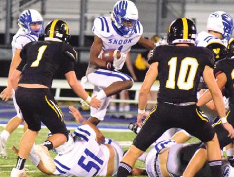 SNOOK’S CAMERON CONERWAY jumps over linemen for positive yardage during the Bluejays’ 52-23 win over Yorktown last Friday night at Altair Rice. -- Tribune photo by Denise Hornaday