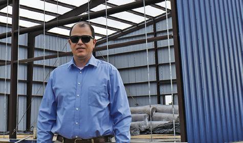 ADAM JANAC STANDS at the construction site for the C-LARS building in Snook. Tribune photo by Roy Sanders