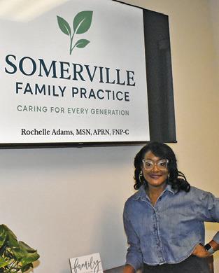 ROCHELLE ADAMS stands next to this sign at the clinic in Somerville. Tribune photo by Roy Sanders