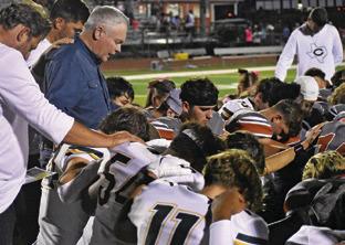 CALDWELL AND LEXINGTON players pray together on Friday for Jurian Moore who was injured in the game. Tribune photo by Roy Sanders