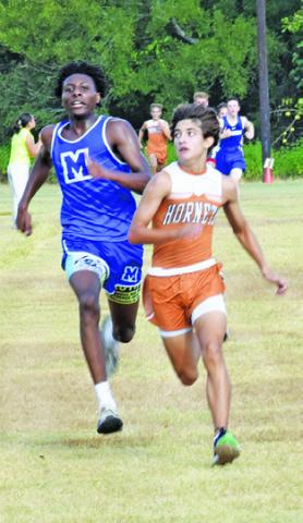CALDWELL’S SPENCER ELLIS, right, and Mumford’s Braeden Mack fight for first place at the finish line of the high school boys race at Saturday’s Caldwell Cross Country Invitational. -- Tribune photo by Roy Sanders