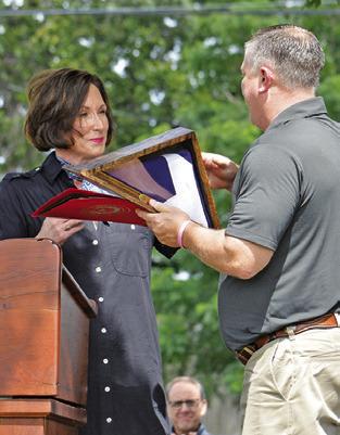 STATE SEN. LOIS Kolkhorst presents this flag to Aaron Flencher of Citizens State Bank.