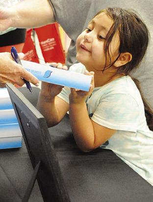 THIS CHILD IS receiving a box of tissues from Caldwell Main Street during the annual Back-to-School Blast on Monday. Tribune photo by Denise Squier