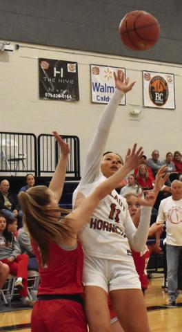CHASSIDY ROGERS attempts a layup over Bellville’s Addison Hollomon during the Lady Hornets’ home loss on Friday. Tribune photo by Roy Sanders