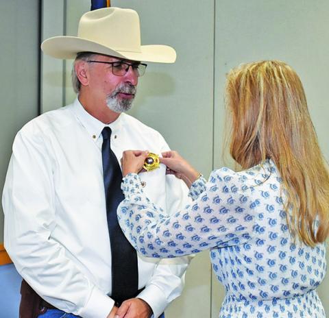 DAVID SIMMONS gets his badge as Burleson County chief deputy at the Monday, July 14, swearing in ceremony at the civic center.