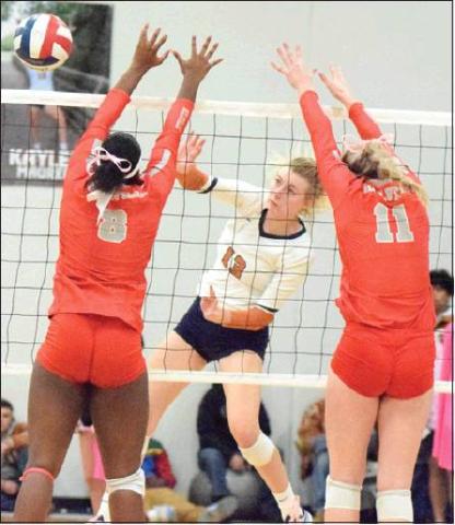 CALDWELL’S MARLEY MAURER hits the ball past Bellville’s Kearstin Carter and Robbin Rice during the Lady Hornets’ loss to the Brahmanettes on Friday. -- Tribune photo by Denise Hornaday