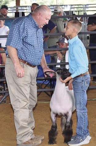 BLAINE DUDENSING shows his lamb as Judge Marty Gibbs offers a comment.