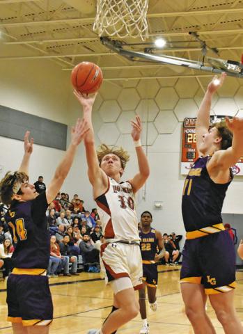TRAVIS CUNNINGHAM OF Caldwell leaps high for this shot as La Grange defenders try to block it. -- Tribune photo by Roy Sanders