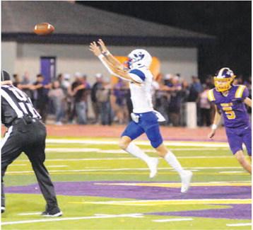 BRETT WITHEM OF SNOOK reaches high for this pass against Weimar last Friday.