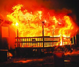 FLAMES ERUPT FROM the porch area of this house at Beaver Creek Subdivision. Photo courtesy of Snook Volunteer Fire Dept.
