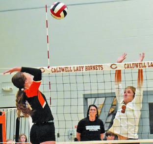 CALDWELL’S MOLLY MEADOWS leaps to attempt a block during the Lady Hornets’ win over Smithville on Friday at Hornet Gym. Tribune photo by Roy Sanders