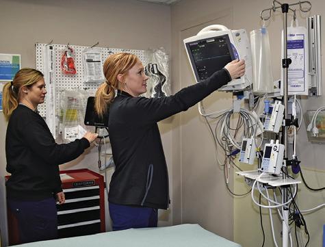 AMANDA KEMPER AND Kristi Splawn, both Registered Nurses, look over this equipment in the hospital’s emergency room. Tribune photo by Roy Sanders