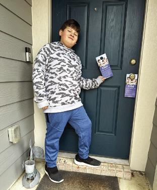 JAKE BARON is pictured putting out door hangers for the “Scouting for Food” event. The local Cub Scout Pack is participating in this event to gather food and donations for the Elizabeth Lutheran Church Pantry.