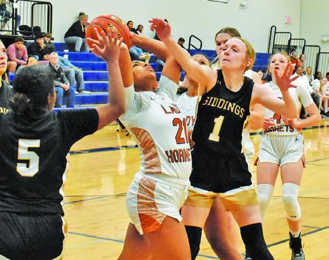 CALDWELL’S AVELYNN O’RILEY fights with two Giddings players during the Lady Hornets home loss last Friday night at Hornet Gym.