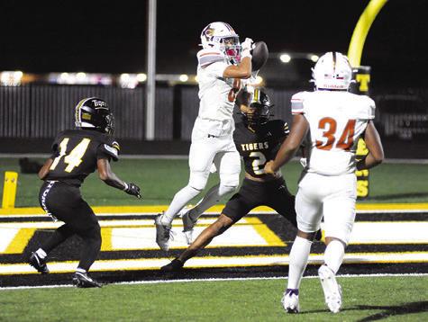 DYLAN CARTER OF Caldwell reaches for this pass against Sealy. Also pictured is teammate Michael Butler. Tribune photo by Denise Squier