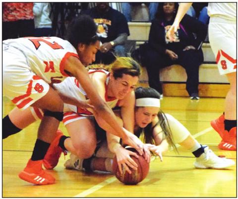 SOMERVILLE’S RA’MAYA Carter and Maddie Knox fight for possession of the ball with Snook’s Riley Green during their battle for first place in District 26-2A Friday. -- Tribune photo by Denise Hornaday