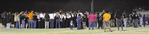 FANS, PLAYERS AND COACHES come onto the field to pray for Bartlett’s Frankie Gonzales. Gonzales was injured during the game and transported by ambulance to an area hospital.