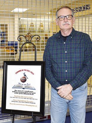 AUTHOR JOHN COUSSONS displays this exhibit promoting his upcoming book on Snook Bluejays basketball history.