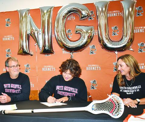 KIEFER ELLIS SIGNS his letter of intent with North Greenville University for a lacrosse scholarship. His joined by his parents David and Melanie Ellis. -- Tribune photo by Roy Sanders