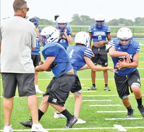 FULLBACK JACOB CASTANEDA takes the handoff from quarterback Caden Schluens. Also pictured is left guard Richard Santillan. The Bluejays are getting ready for the 2021 football season.