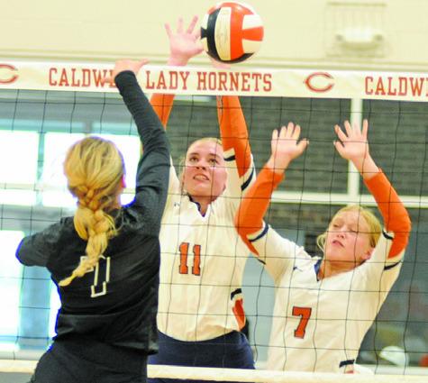 JACKIE PINKERTON blocks a hit from a Sealy middle blocker during the Lady Hornets’ 14-25, 23-25, 15-25 loss Friday night. Also pictured is Caitlyn Faust. See story inside. -- Tribune photo by Denise Squier
