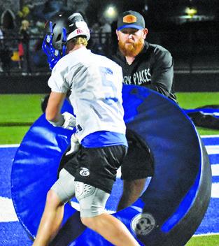 MICHAEL EATON is pictured with Coach Nolan Lanham working on this Friday night drill.