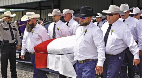 SHERIFF GENE HERMES is carried from the Burleson County Cowboy Church to his burial at Providence Baptist Church. Local residents also paid tribute along the route past the Burleson County Courthouse and past the sheriff’s office on State Highway 21 East. Tribune photo by Roy Sanders