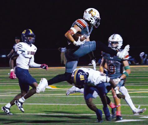 COY BECKA OF Caldwell leaps over this defender in the Hornets’ game against La Grange last Friday night. Tribune photo by Kim Hutcheson