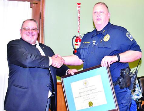KEVIN LUNDSFORD, left, of the Texas Police Chiefs Association, presents the accreditation to Somerville Police Chief Jake Sullivan.