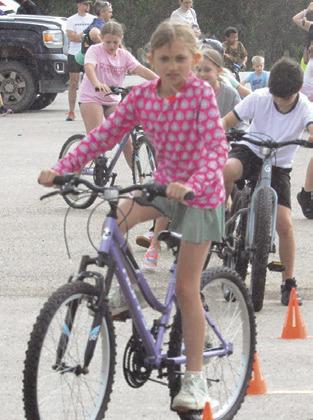 THOUGH IT BEGAN to rain during Friday’s bicycle rodeo, bicyclists took on an obstacle course with ease. Tribune photo by Denise Squier