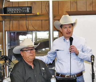 CARL RAY POLK JR., right, addresses the crowd as Milton Charanza listens at the Saturday sale at Caldwell Livestock Commission.