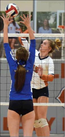 ELIZABETH SEE HITS the ball past a Rock-dale blocker Friday night at Hornet Gym. See had 11 kills for the Lady Hornets on Friday.