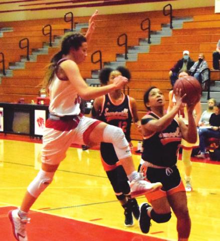 SOMERVILLE’S JAZMINE JACKSON is about to be fouled by Deweyville’s Emilee Totino during the Lady Yeguas’ bi-district game last Thursday night in Tomball. -- Tribune photo by Denise Squier