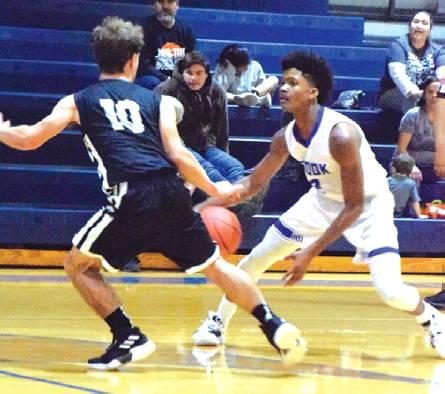 SNOOK’S JERMAINE KEARNEY tries to dribble past Moulton guard Braden Kram during the Snook-Moulton game last Tuesday night at Snook High School. -- Tribune photo by Denise Hornaday