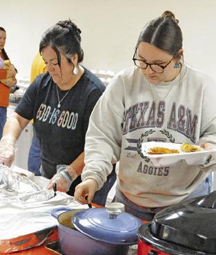 MEMBERS OF CALDWELL Assembly prepare plates of food for those attending a Thanksgiving lunch last Thursday afternoon. Tribune photo by Denise Squier