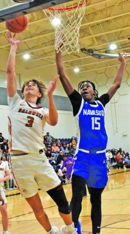 DYLAN CHAPMAN of Caldwell leaps high for this basket against Navasota. Tribune photo by Roy Sanders