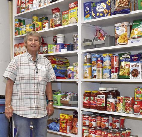 DIANE GANSKE STANDS next to this large display of canned goods at the SAAM House at their open house on Saturday, Nov. 15.