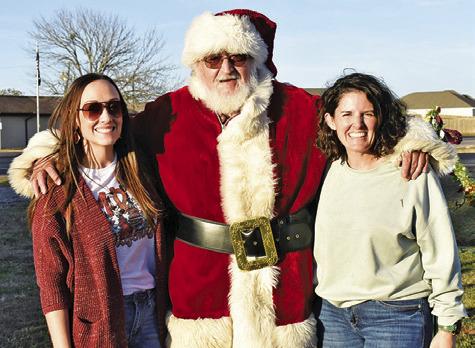 LAUREN WILLIAMS AND Jamie Hardin with the Snook Education Foundation join Santa Claus at the Bluejay Trail of Lights.