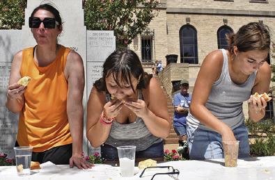 CONTESTANTS IN THE Women’s division eat as fast as they can.