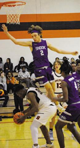 SOMERVILLE’S JAKEITH Daniels comes down with the ball as Snook’s Brett Withem jumps high. Snook won 51-36. Tribune photo by Denise Squier