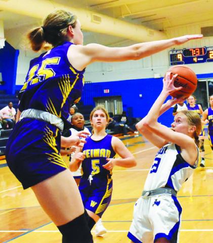 SNOOK’S DAKOTA KIENOW looks to take a shot while a Weimar player attempts to block her shot during last Friday’s Snook-Weimar game in Snook. The Lady Jays fell to the Lady Wildcats 33-17.