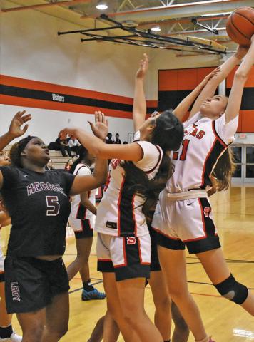 SOMERVILLE’S BRIDGET KALDIS grabs a rebound over several Somerville and Hearne players during the Lady Yeguas home game last Friday night at the Somerville High School Gym. Tribune photo by Roy Sanders
