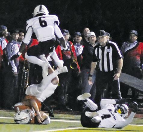 COY BECKA DIVES for yardage as these Madisonville players defend. Tribune photo by Denise Squier