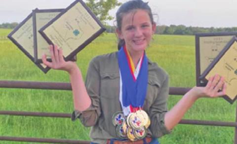 LORELAI BROWN shows her awards and medals she won at the 4-H Shooting Sport State Game. She placed in 16 of 23 events.