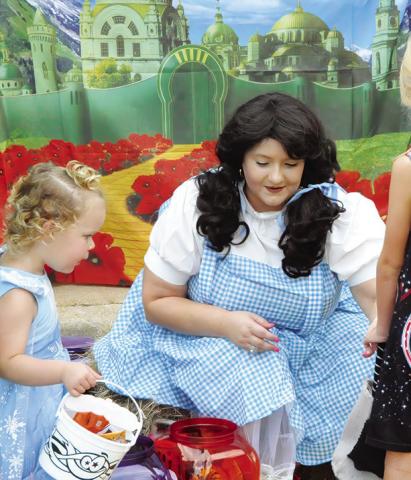 THERE’S NO PLACE LIKE HOME, except maybe at Saturday’s “Scare on the Square” where even Dorothy from The Wizard of Oz made an appearance to pass out candy to area children. Tribune photo by Denise Squier