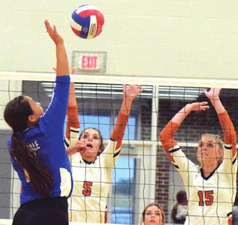 CALDWELL’S CAYLEE GARZA and Lexie Albright reach to try to block a hit from a Rockdale player last Tuesday during Caldwell’s win over the Lady Tigers. -- Tribune photo by Denise Squier