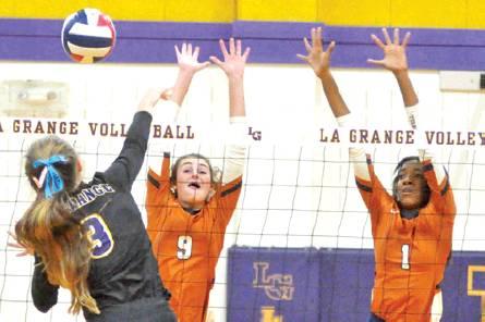 CALDWELL’S CORINNE DILLARD and Aaliyah Massingill reach to attempt to block a hit from La Grange’s Lanie Doyle during the Lady Hornets’ win over La Grange. -- Tribune photo by Roy Sanders