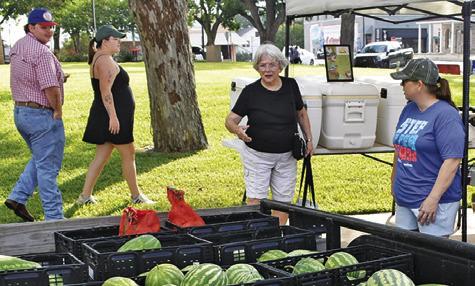 JENNIFER BONIOL, right, works at the Farmers Market on Saturday in downtown Caldwell.