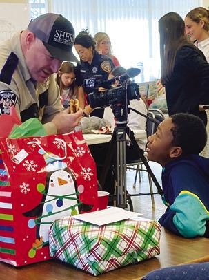 A DEPUTY CHATS WITH A STUDENT who participated in the Shop with a Cop event. Tribune photo by Sabine Lazo